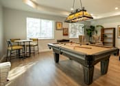 Thumbnail 16 of 22 - A pool table is in the middle of a room with a light hanging from the ceiling.