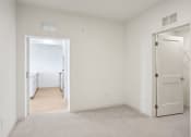 Thumbnail 42 of 63 - a bedroom with white walls and a door to a hallway