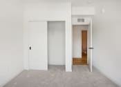 Thumbnail 40 of 63 - a bedroom with white walls and a closet with white doors