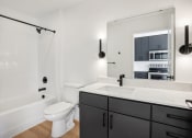 Thumbnail 61 of 63 - a black and white bathroom with a white toilet and a sink