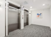 Thumbnail 49 of 63 - an empty room with two elevators and a painting on the wall