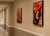 Thumbnail 7 of 22 - Two paintings of a woman with flowers in her hair hang on a wall in a hallway.