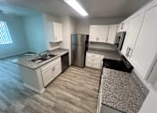 Thumbnail 11 of 22 - A kitchen with a granite countertop and a stainless steel refrigerator at Madison Highlands 2 Tampa Florida