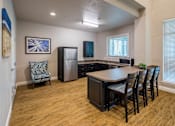 Thumbnail 5 of 11 - A kitchen with a dining table and chairs.