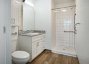Thumbnail 6 of 30 - A white bathroom with a toilet, sink, and shower.