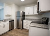 Thumbnail 1 of 30 - A kitchen with white cabinets and a granite countertop.