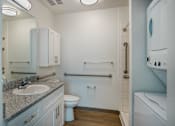 Thumbnail 10 of 30 - A bathroom with a toilet, sink, and mirror.