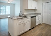 Thumbnail 11 of 30 - A kitchen with white cabinets and a granite countertop.