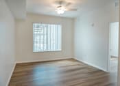 Thumbnail 13 of 30 - A room with a window and wooden floors.