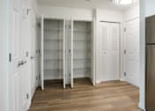 Thumbnail 21 of 30 - A kitchen with a refrigerator, cupboards and a pantry.