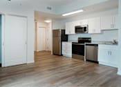 Thumbnail 17 of 30 - A kitchen with white cabinets and a black fridge.