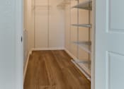 Thumbnail 5 of 30 - A walk-in closet with shelving and a light on the ceiling.