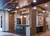 Thumbnail 8 of 13 - A reception area with a wooden floor and a green reception desk.