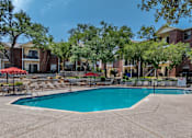 Thumbnail 4 of 35 - A swimming pool surrounded by trees and chairs.