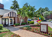 Thumbnail 5 of 35 - Park at Wells Branch leasing office is located in a landscaped area with a striped awning.