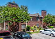 Thumbnail 3 of 35 - A red brick building with a black car parked in front.