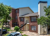 Thumbnail 11 of 35 - A two-story apartment building with a brick facade and a white exterior.