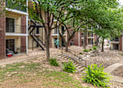 Thumbnail 6 of 35 - A tree in front of a brick building with a staircase.