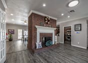 Thumbnail 34 of 35 - A living room with a fireplace and a ceiling fan.