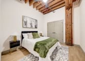Thumbnail 19 of 41 - a bedroom with a bed and a green blanket at Greeley Lofts, Missouri