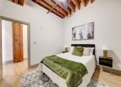 Thumbnail 22 of 41 - a bedroom with a bed and a green blanket at Greeley Lofts, St. Louis