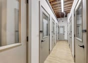 Thumbnail 26 of 41 - a hallway filled with doors and windows in a building at Greeley Lofts, St. Louis