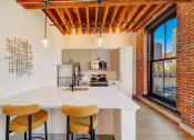 Thumbnail 3 of 41 - a kitchen with a white counter top and a large window at Greeley Lofts, St. Louis, MO, 63102