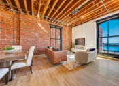 Thumbnail 10 of 41 - a living room with a couch and a table and a tv at Greeley Lofts, St. Louis, MO