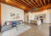 Thumbnail 4 of 41 - a living room with a couch and a kitchen in the background at Greeley Lofts, St. Louis, 63102