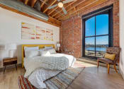 Thumbnail 21 of 41 - a bedroom with a bed and a large window at Greeley Lofts, St. Louis, MO