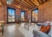Thumbnail 7 of 41 - a living room with a couch and a large window at Greeley Lofts, Missouri