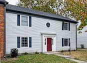 Thumbnail 13 of 18 - A house with a red door and a grey siding.
