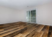Thumbnail 11 of 31 - a bedroom with hardwood floors and a door to a balcony