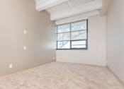 Thumbnail 40 of 58 - an empty living room with a window and carpet