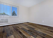 Thumbnail 7 of 23 - a bedroom with hardwood floors and white walls