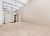 Thumbnail 38 of 58 - an empty living room with a beige carpet and white walls