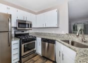 Thumbnail 9 of 31 - a kitchen with granite countertops and stainless steel appliances