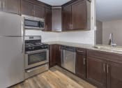Thumbnail 1 of 31 - a kitchen with dark wood cabinets and stainless steel appliances