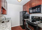 Thumbnail 1 of 25 - a kitchen with black appliances and granite countertops