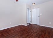 Thumbnail 3 of 25 - a bedroom with hardwood floors and white walls