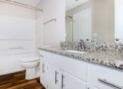 Thumbnail 14 of 31 - a bathroom with white cabinets and a white toilet