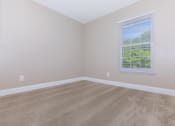 Thumbnail 15 of 31 - a bedroom with beige carpet and a large window