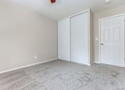 Thumbnail 12 of 23 - a bedroom with a carpeted floor and a white door