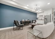 Thumbnail 40 of 44 - A modern living room with a glass coffee table and a white chair. at Park Lamont Townhomes Apartments, Cleveland, OH, 44106