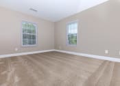Thumbnail 4 of 31 - a bedroom with a carpeted floor and three windows