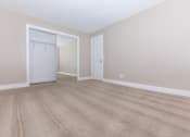 Thumbnail 16 of 31 - a bedroom with a door to a closet and a carpeted floor