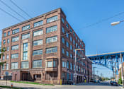 Thumbnail 57 of 58 - a large brick building with a bridge in the background
