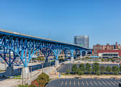 Thumbnail 55 of 58 - a bridge over a parking lot with a city in the background