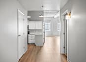 Thumbnail 1 of 58 - A kitchen with white cabinets and a wooden floor.