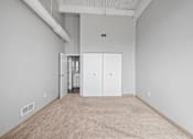 Thumbnail 15 of 58 - A room with white walls and carpeted floor with a white door in the middle.